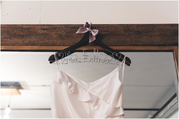 Wedding Dress hanging in front of mirror at the Fremont Foundry in Seattle. Image captured by Ardita Kola Photography.