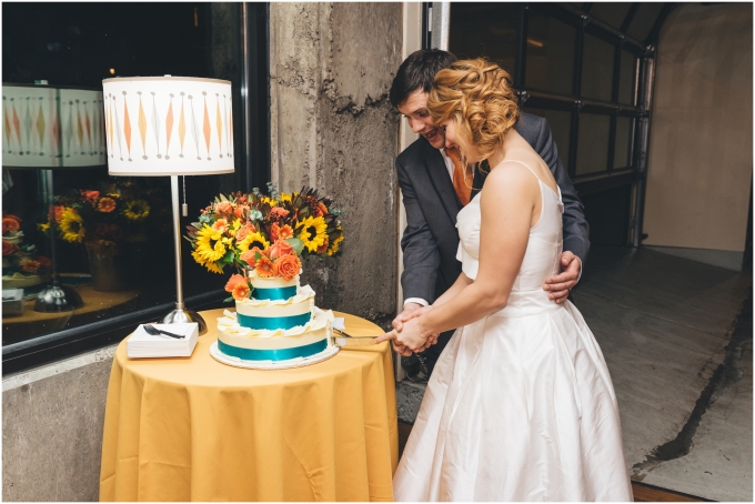Bride and groom cut the cake during wedding reception at the Fremont Foundry in Seattle. Image captured by Ardita Kola Photography.